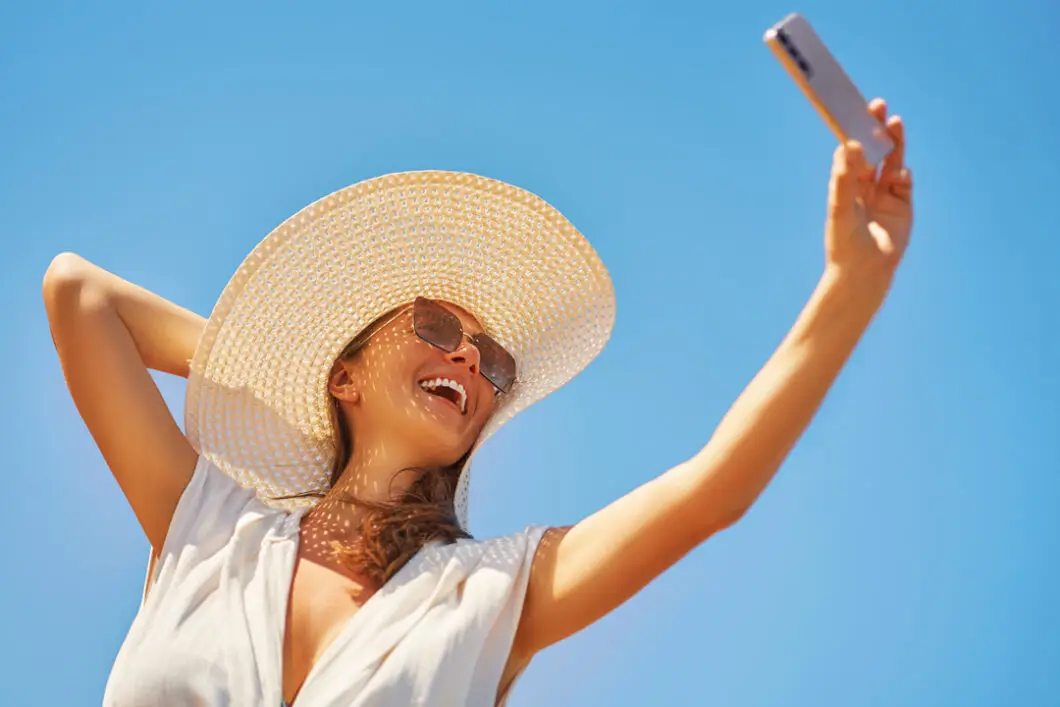 L'immagine mostra una ragazza mentre si scatta un selfie. Se da un lato i social hanno trasformato i più comuni inestetismi in peculiarità da esibire con orgoglio, grazie alle campagne body positive, dall’altra hanno contribuito a far interiorizzare ideali estetici utopici: sempre più persone oggi si rivolgono a chirurghi plastici e medici estetici chiedendo di acquisire canoni di bellezza stereotipati e non necessariamente allineati alla loro fisionomia.